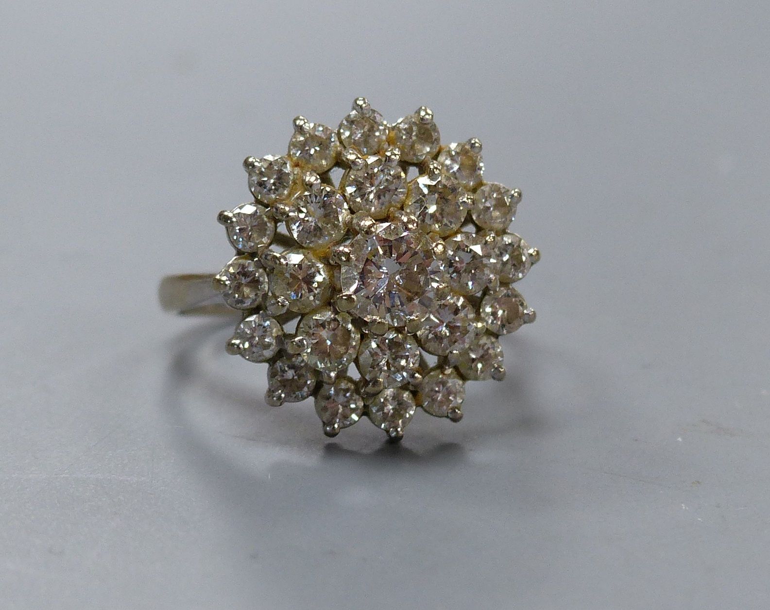 A twenty-five stone graduated cluster diamond ring, claw-set in platinum, size M, gross weight 5.7 grams.